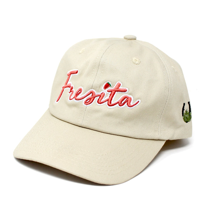 Front view of Khaki Fresita Dad Hat with embroidered red script and small strawberry detail on the letter i and view of the Mex West Logo on side