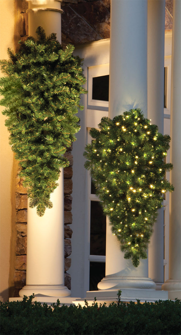 Decorative olympia pine sprays with lights hanging on columns outdoors
